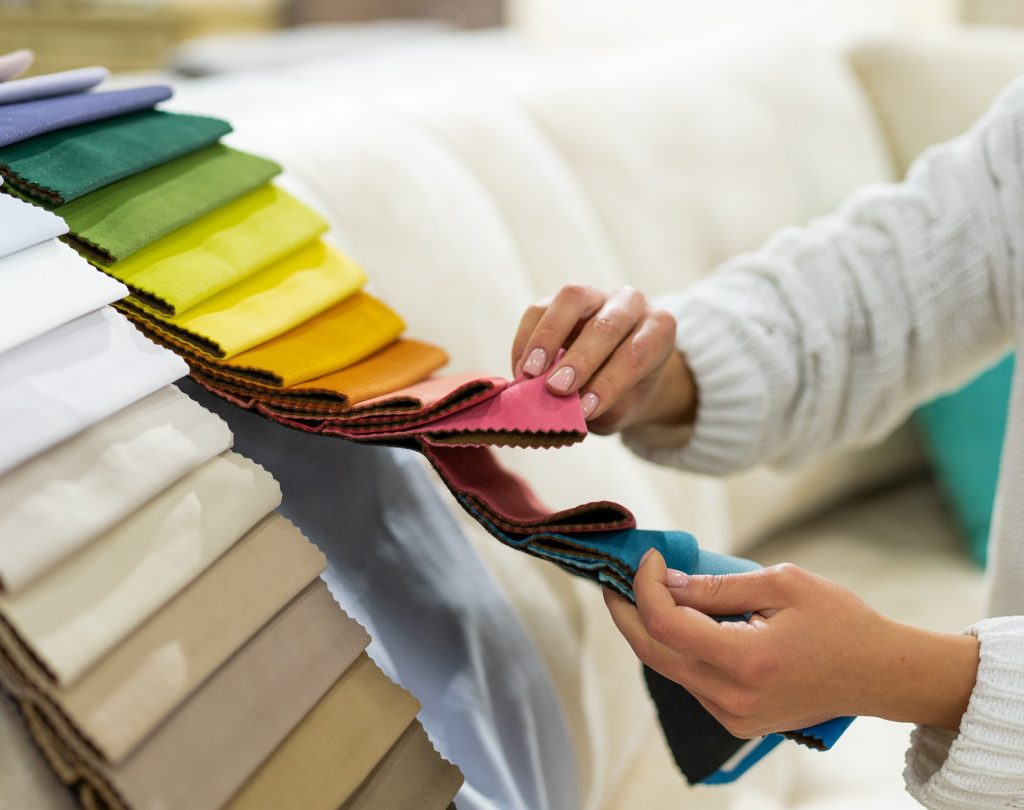 the-woman-chooses-the-fabric-on-the-sofa-textile-industry-background-tissue-catalog.jpg